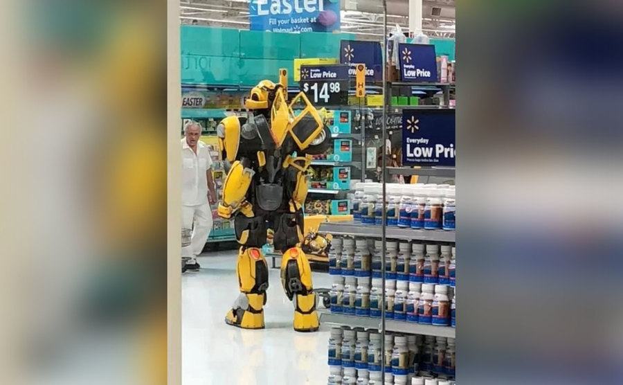 Someone shops while dressed in a transformer costume. 