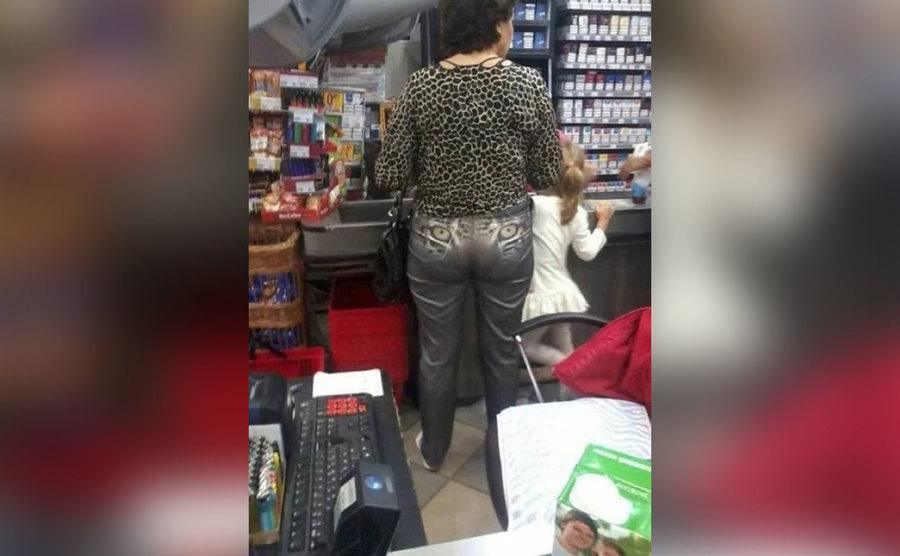The back of this woman's pants has leopard eyes on them. 