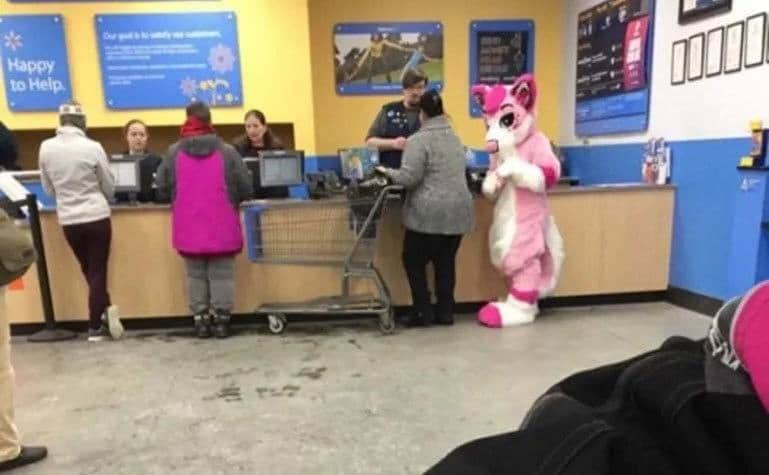A customer dressed in a bunny suit stands in line at the customer service desk. 