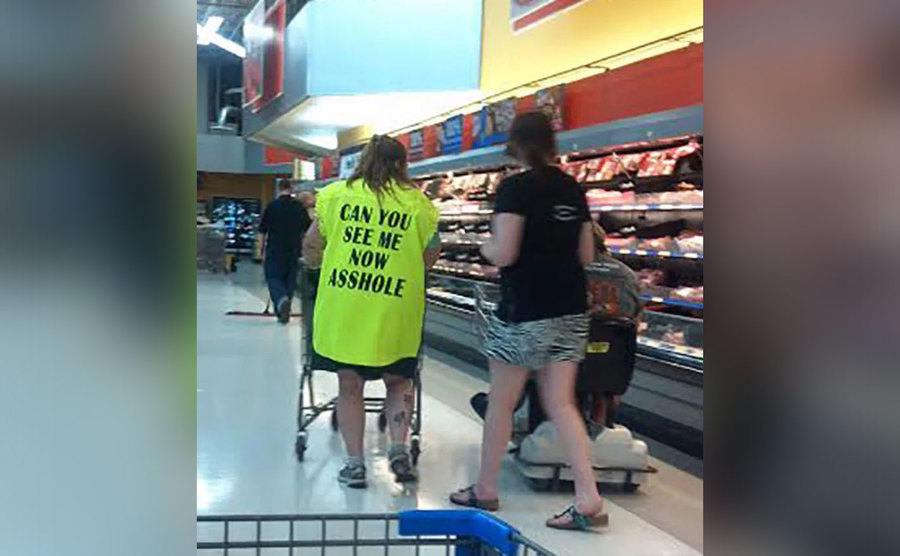 A woman is wearing a neon yellow vest that says 