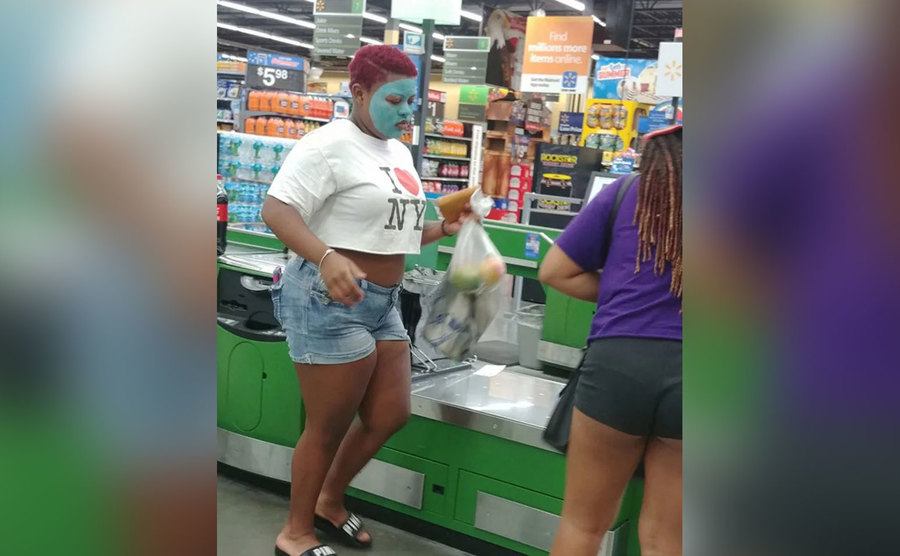 A woman shops while still wearing her cleansing facemask. 