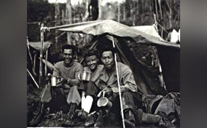 The survivors sit in a makeshift tent. 