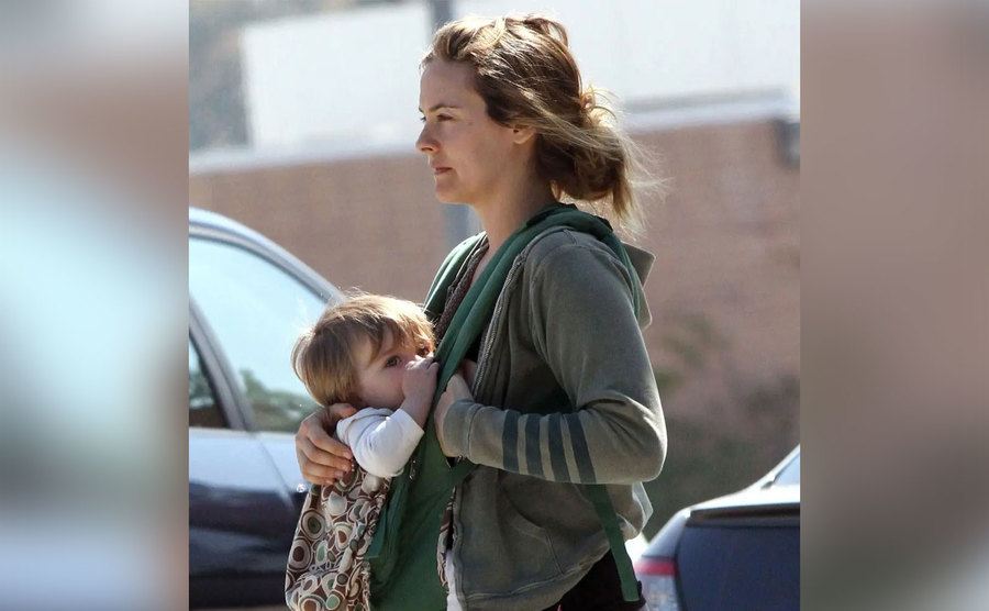 Alicia walks with Bear in a baby carrier. 